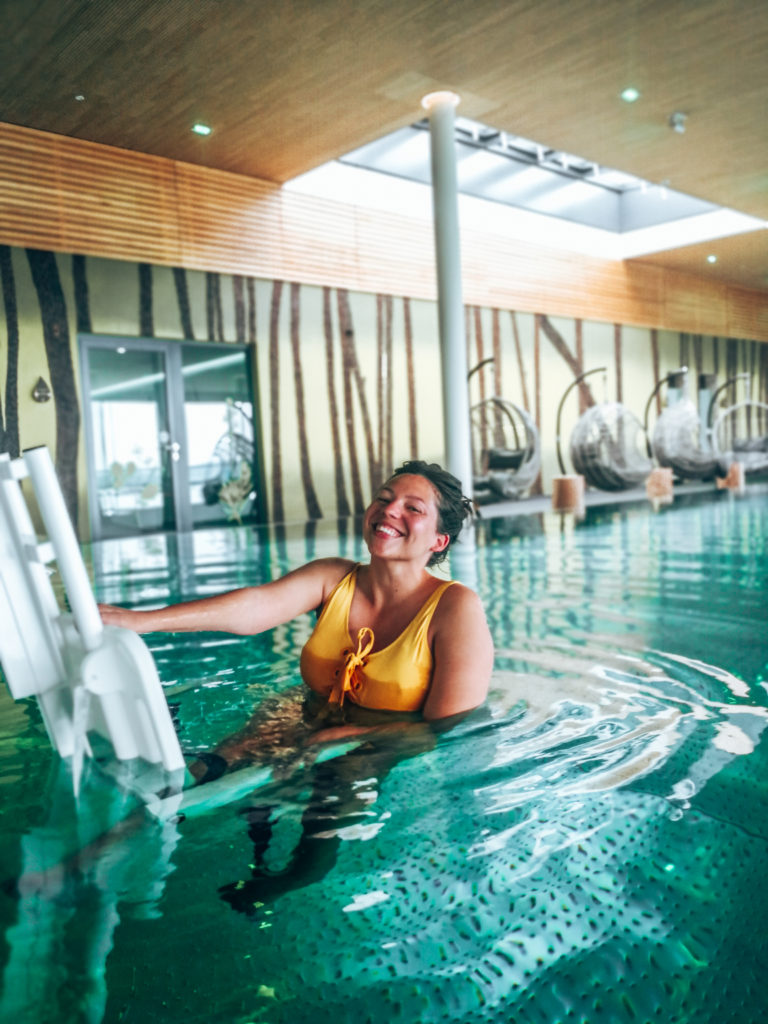 Man sieht Kim von Wheeliewanderlust auf dem Poollift im PanoramaSpa der BioSeehotels in Zeulenroda